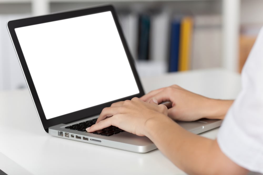 Rear view of business woman hands busy using laptop at office desk, with copyspace Rear view of business woman hands busy using laptop at office desk, with copyspace
